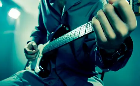 A focused bass guitarist performing on stage.