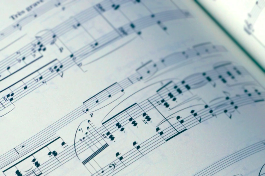 Extreme close-up view of printed sheet music showing detailed musical notation.